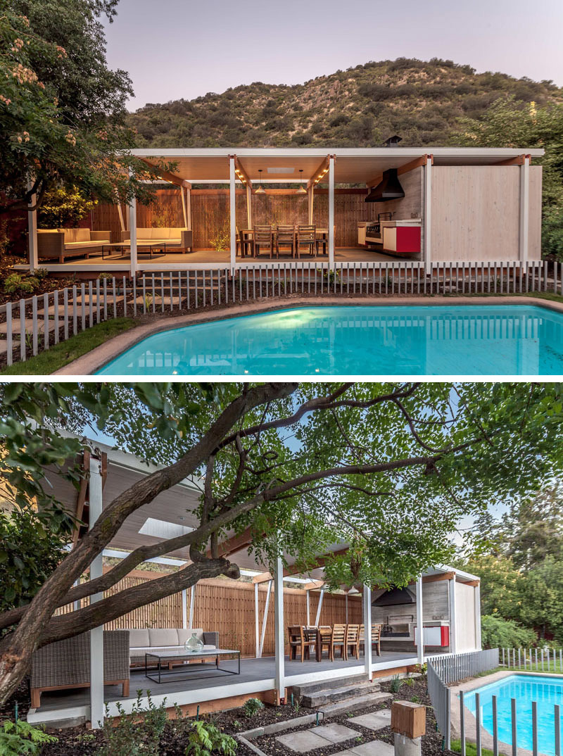 Slightly raised from the ground, this modern pool house with steel white pillars provides a mostly unobstructed view of the gated outdoor pool.