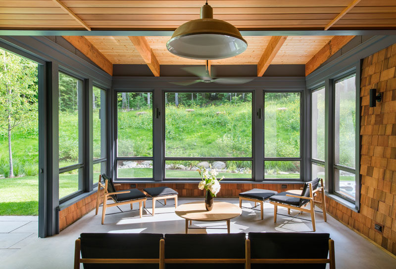 This modern living space has direct access to the backyard. The shingles used on the exterior of the house have also been used as wall coverings in this room.