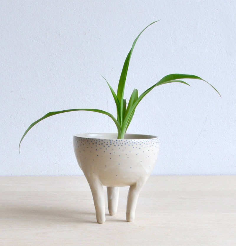 Standing on three legs, this modern blue and white speckled planter is handmade and will bring a dash of charm to any room.