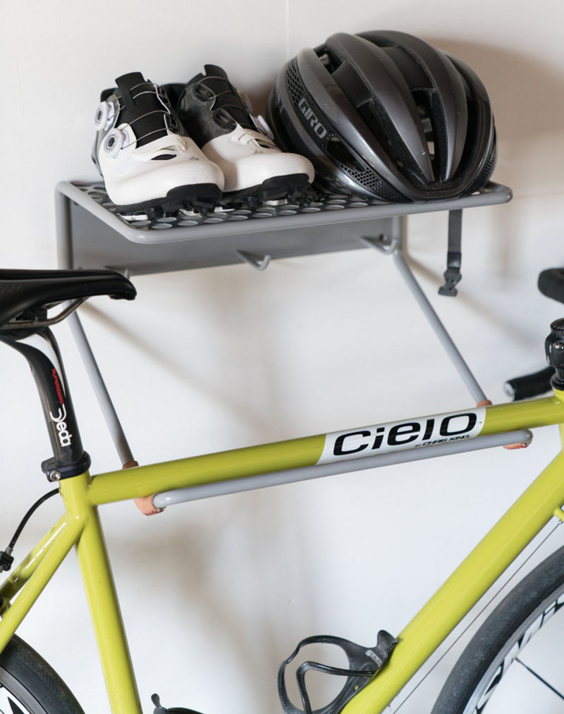 This modern grey steel wall mounted bike rack has a space for your bike, your jackets, shoes, and helmet.