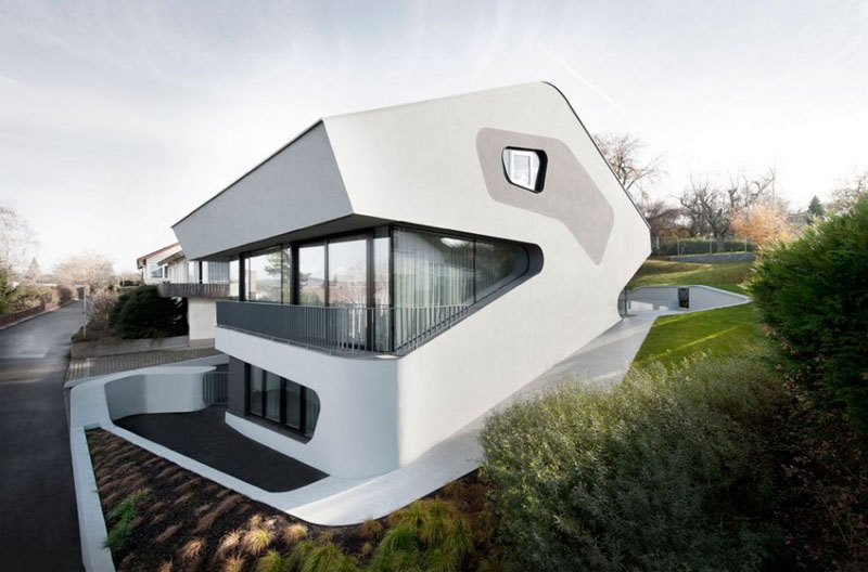 This modern house is white with touches of grey and black, and has curved features throughout.
