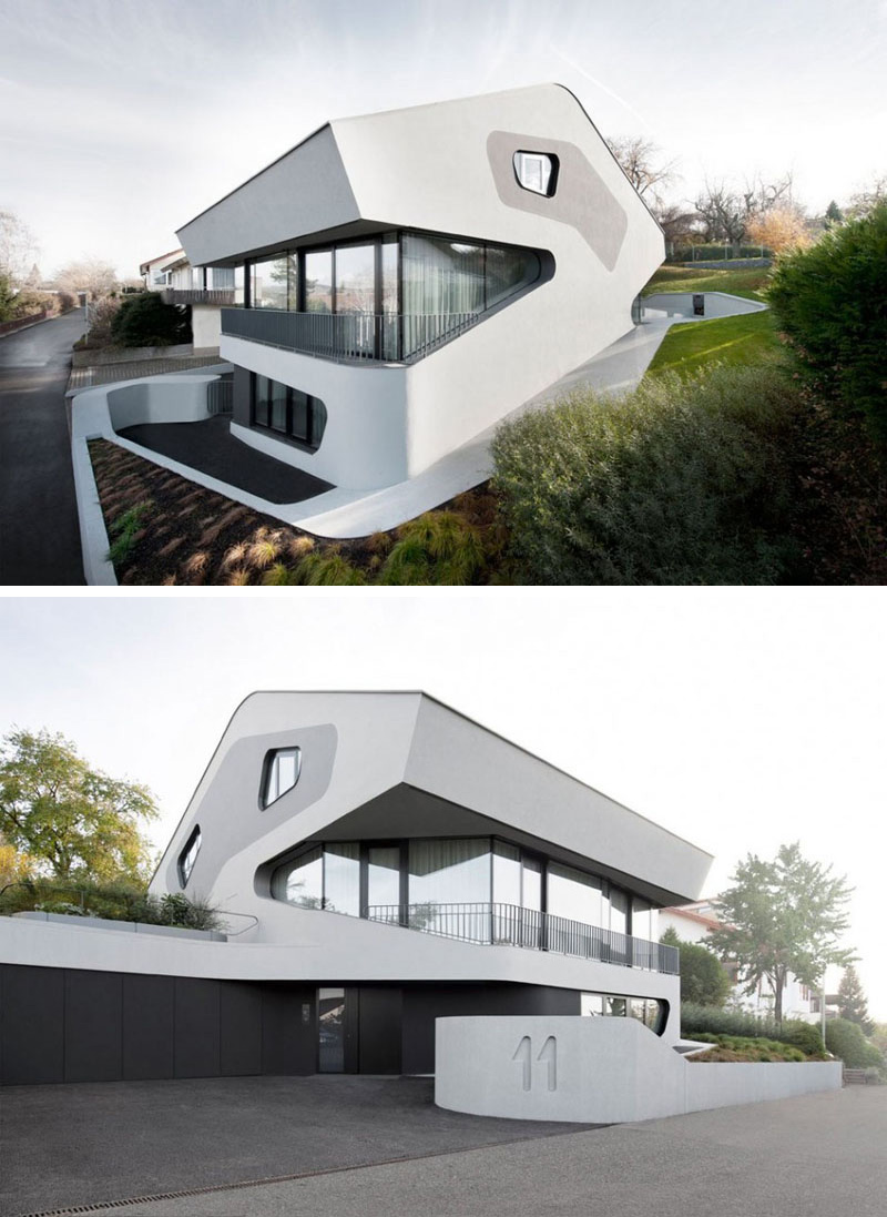 This modern house is white with touches of grey and black, and has curved features throughout.