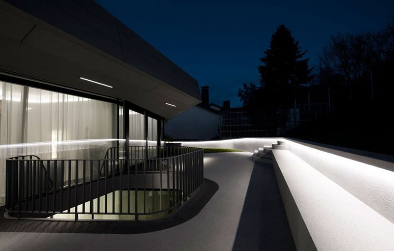 This modern house has a balcony with hidden lighting that lines the white railing, providing light and safety.