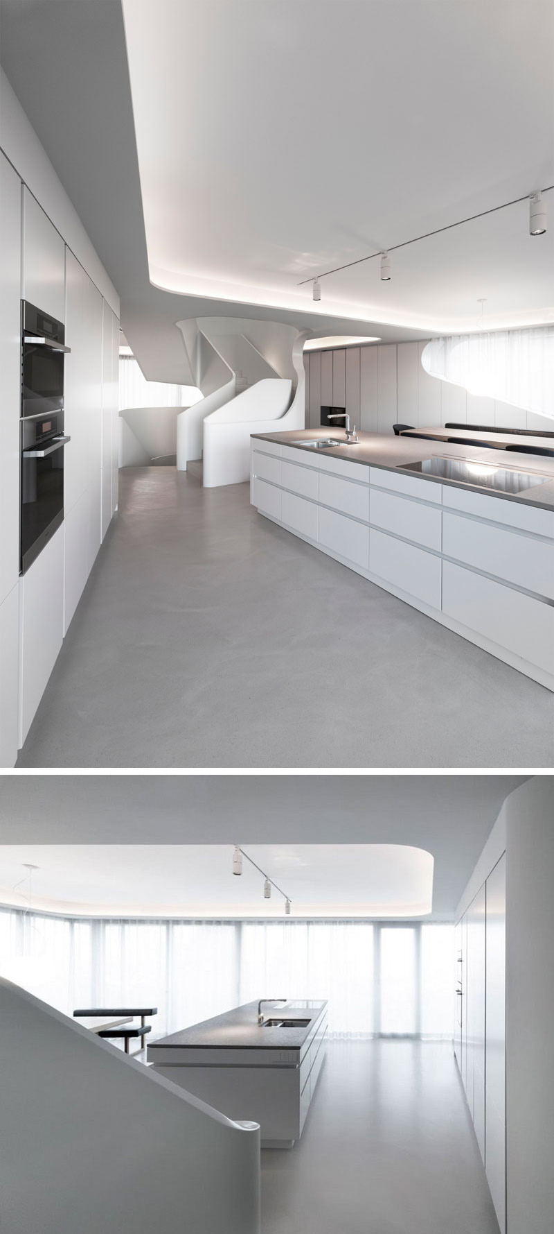 This modern kitchen has track lighting along with hidden lighting in the recessed ceiling, ensuring that the white and grey island is always brightly lit. Large white cabinets and drawers provide plenty of storage in this open kitchen. 