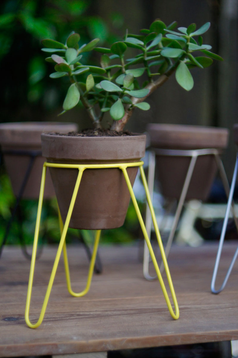 Modern in design and small in size, this yellow steel tripod plant stand is perfect for small plants and herbs.  #PlantStand #ModernPlantStands #Garden #Plants #ModernHomeDecor