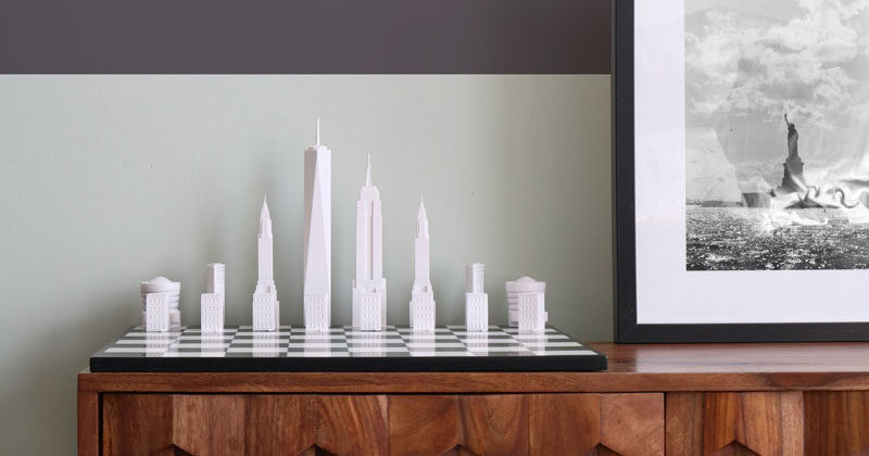 This modern chess set has pieces that represent the New York City skyline and includes buildings like the One World Trade Tower, the Empire State Building, the Chrysler Building, the Flatiron Building, the Guggenheim Museum and a Brownstone House.