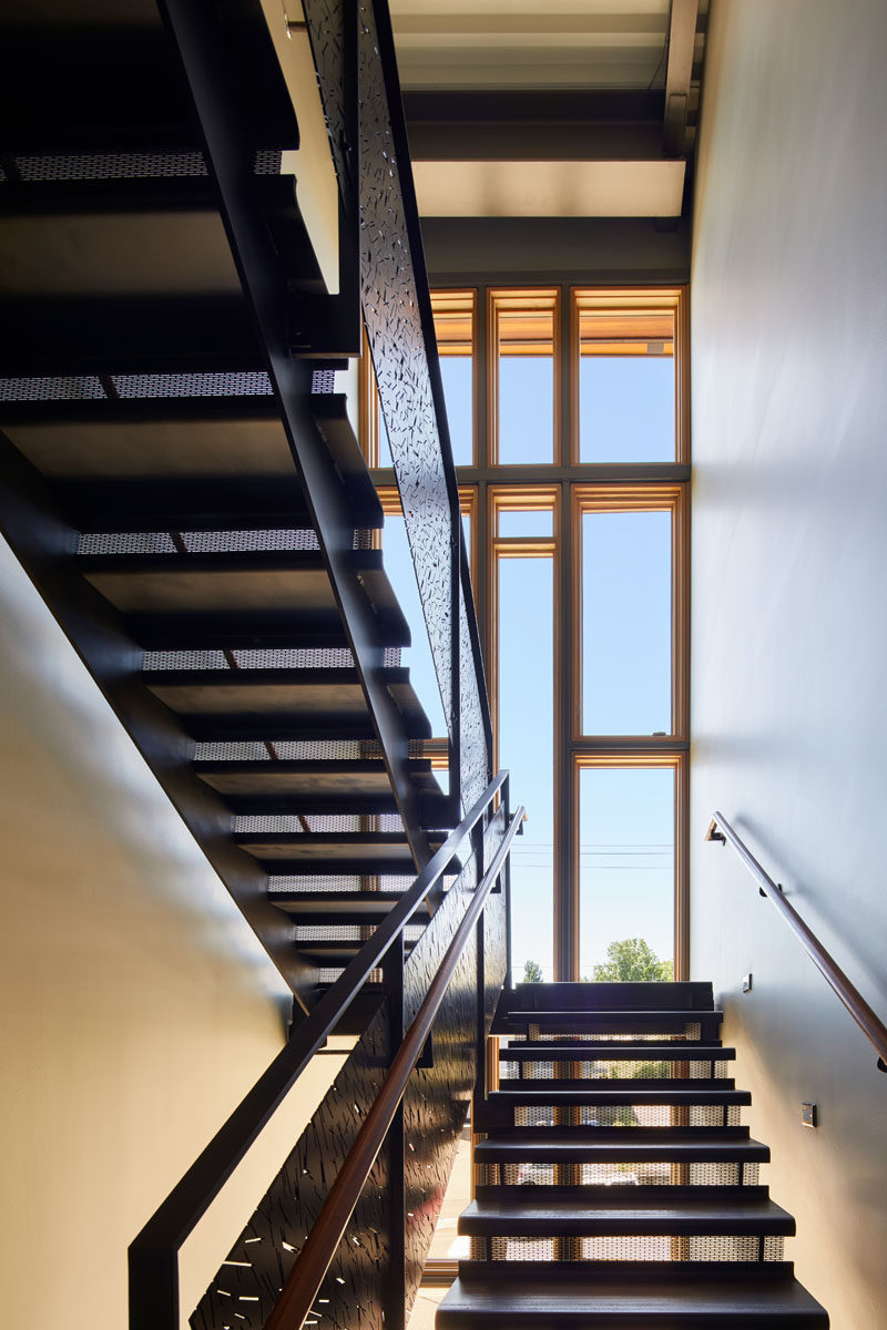 The stairwell has a three-story glass wall that fills the space with natural light. 