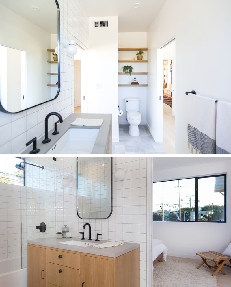 This modern jack and jill bathroom features open wood shelving above the toilet, white black hardware and faucets contrast the square white tiles.