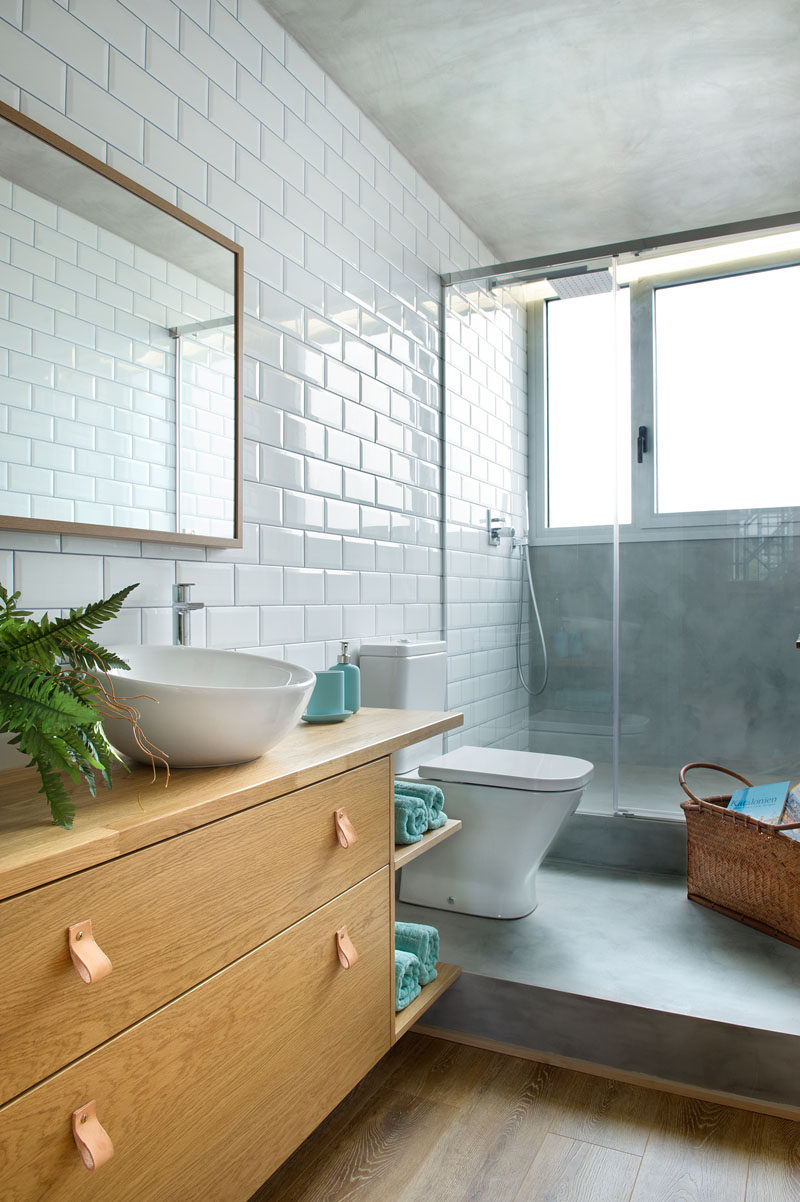 In this modern bathroom, white subway tiles line the wall and brighten up the bathroom. A glass shower screen allows the natural light from the window to pass through to the rest of the bathroom.