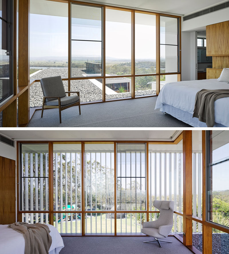 In this modern bedroom, the wood framed windows flood the room with natural light, frame the view and compliment the wood headboard.