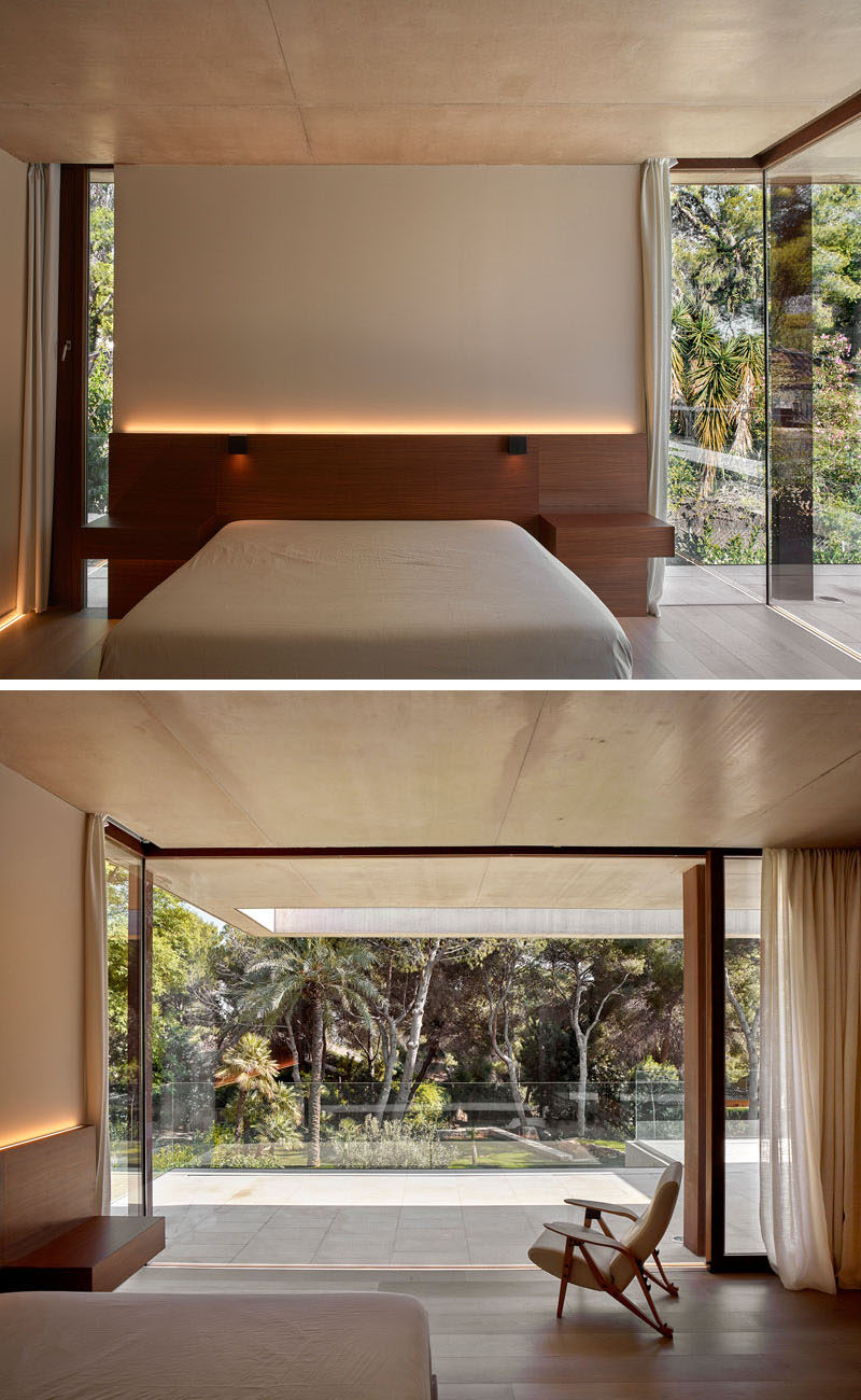 In this modern bedroom, the headboard has hidden lighting, while floor-to-ceiling windows and doors open up to the backyard.