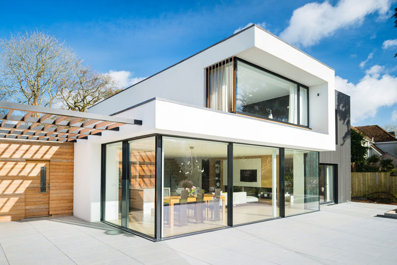 This modern house has large glass windows / doors that open up to the backyard.