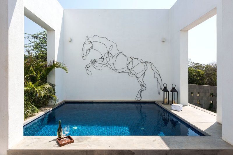 The wire outline of a horse on the wall above a plunge pool adds an artistic touch to this modern house.