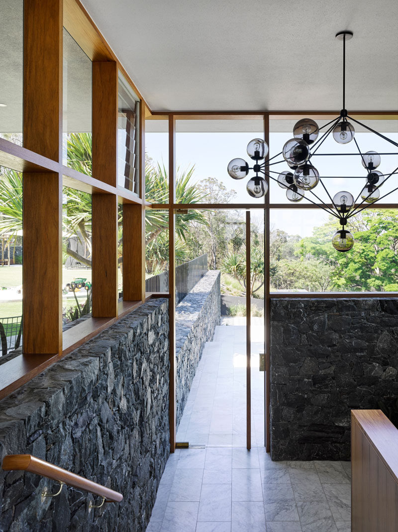 Carrara marble has been used as flooring throughout the home, and wood frames surround the windows. in this modern house.