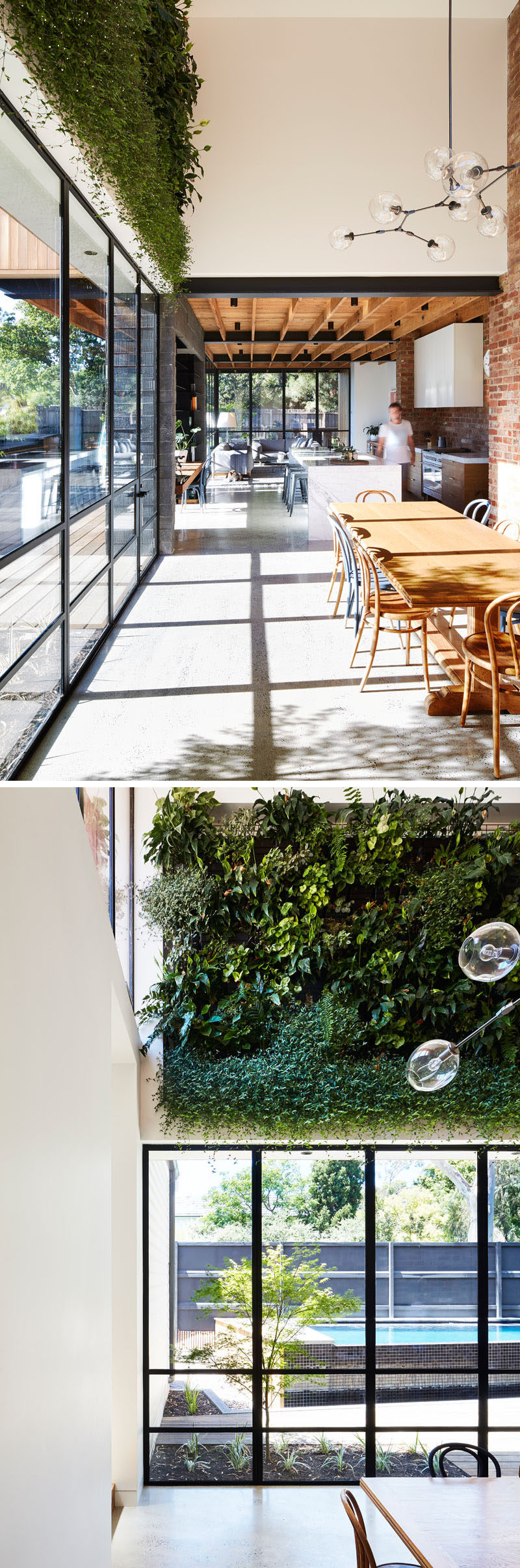 Next to the kitchen in this modern house extension is a two story void over the dining area. The void was created to allow winter sunlight to fill the space. Above the windows in the dining area is a green wall that provides a touch of nature to the room.