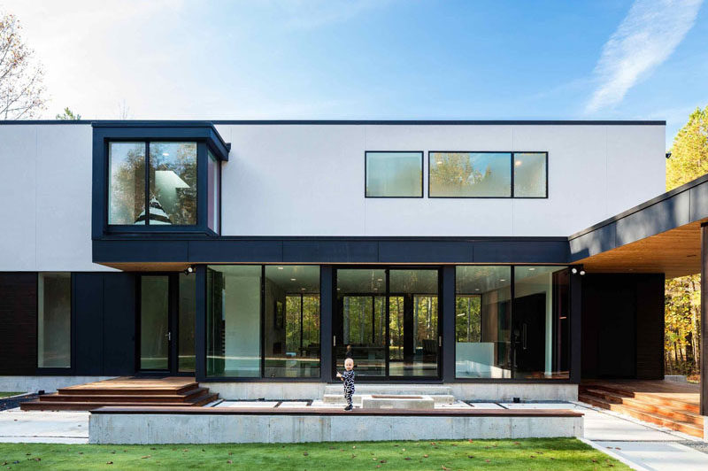 At the front of this modern house there's a covered walkway from the garage to a side entry, while a paved pathway leads to the front door.