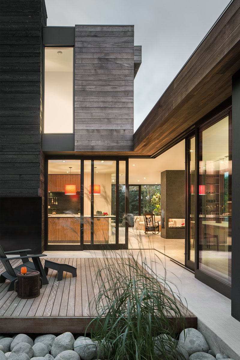 This modern house has operable glass walls that connect the interior spaces with the courtyard, and allow the courtyard to become one of the main gathering places for the home.