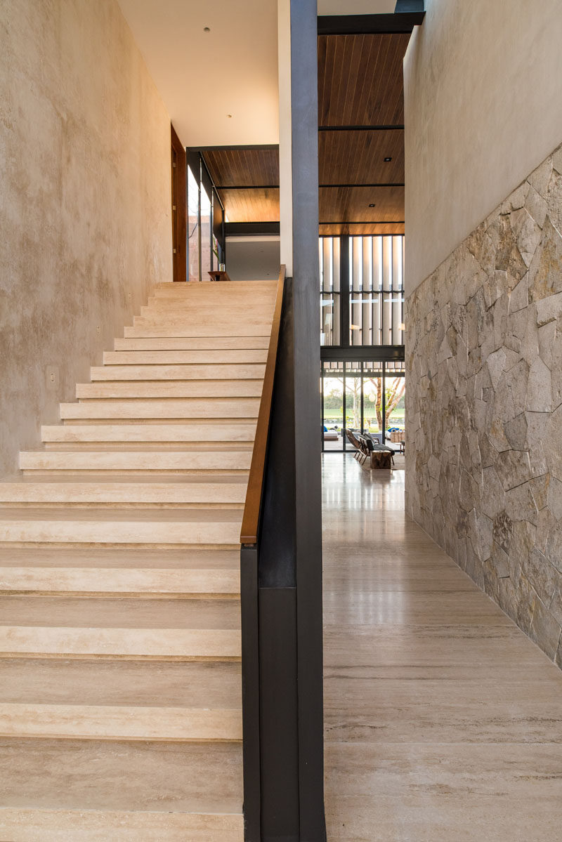 A large stone staircase leads to the upper floor in this modern house.