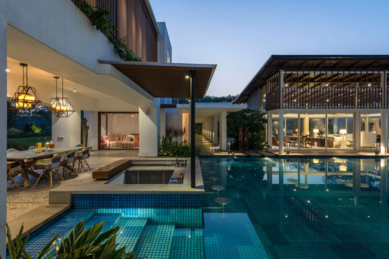 This modern house has a large swimming pool, a swim-up bar and an outdoor dining area.