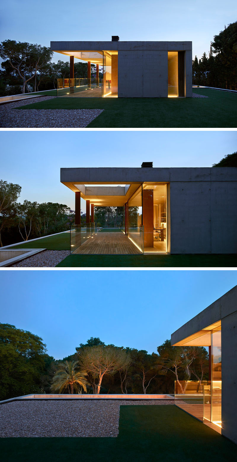 On the top of this modern house there's a room that's been set up as an office that has views of the surrounding landscape.