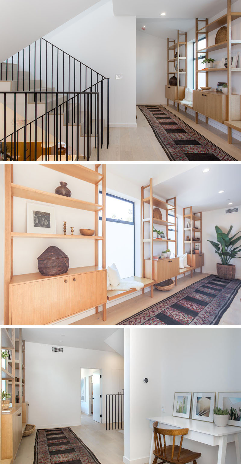 Wide oak flooring covers the upper floors of this modern house, and wood shelving provides the perfect spot for displaying personal items or for sitting and looking out the window.