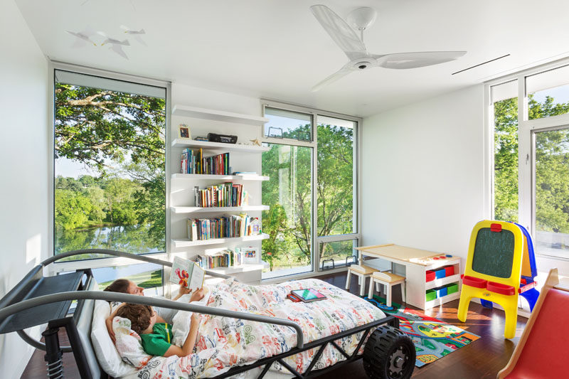 In this boy's bedroom, floor-to-ceiling windows provide views of the treetops, while a car inspired bed creates a sense of fun.