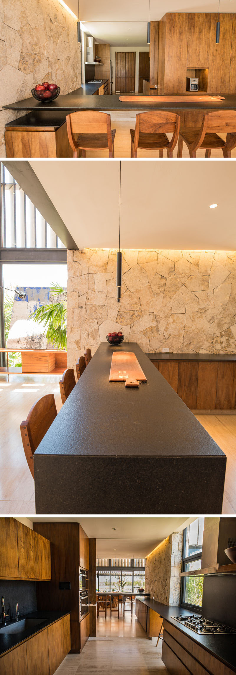 This modern kitchen features a light stone wall with a contrasting dark countertops and wood cabinetry.