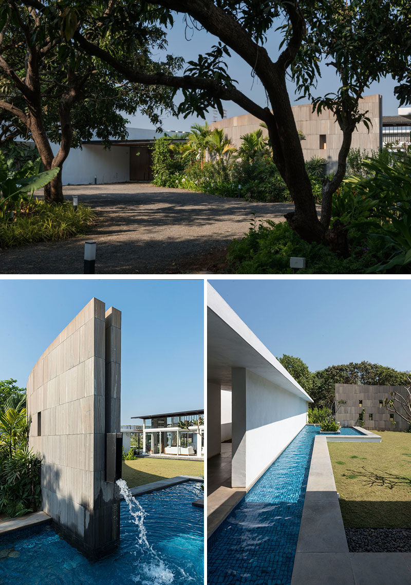 At the front of this modern house is a large curved stone wall that turns into a water feature at one end.