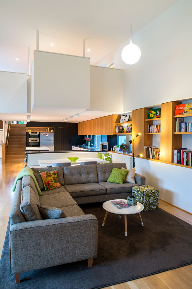 This casual living area has wood shelving and cabinets that run along the wall and lead into the kitchen.