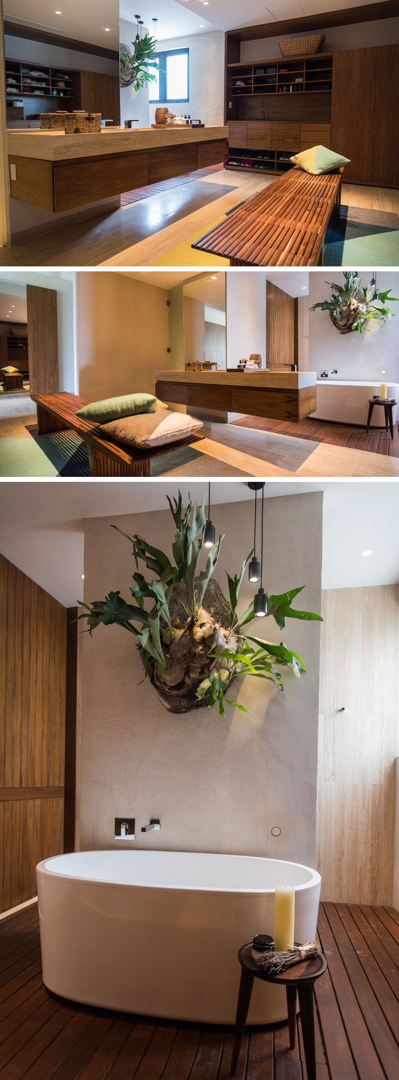 This modern master bathroom features wood shelving and cabinets, and a floating vanity. A standalone white bathtub sits below a large wall-mounted plant. 