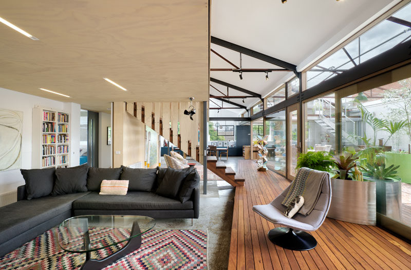 In this modern converted warehouse, the living room is stepped down from the wood deck. Simple lighting has been embedded into the wood ceiling.