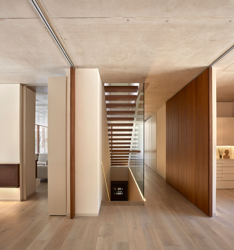 Modern stairs connect all three floors of this home, and the lit up handrail has been built into the wall.