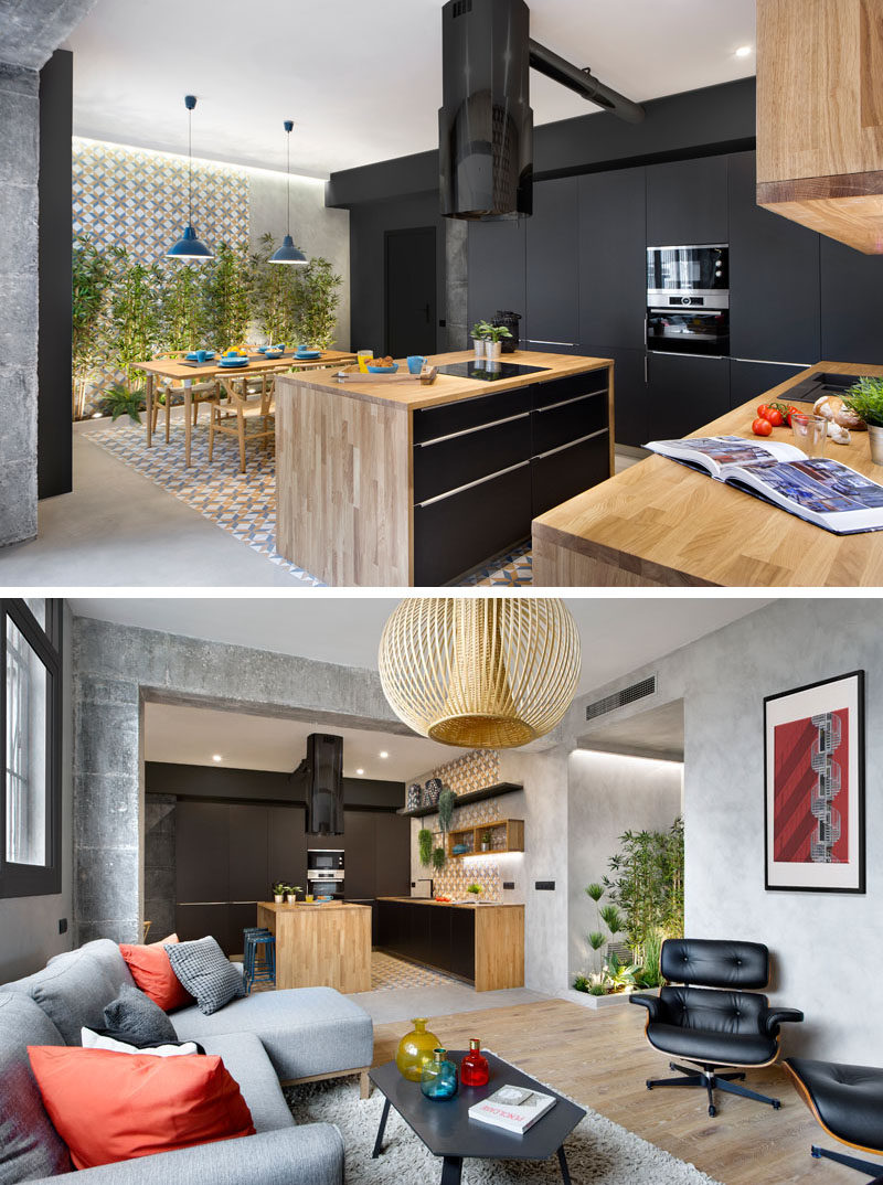 The kitchen in this modern apartment combines matte black and wood cabinets for a contemporary appearance. The use of plants adds a natural touch throughout the apartment.