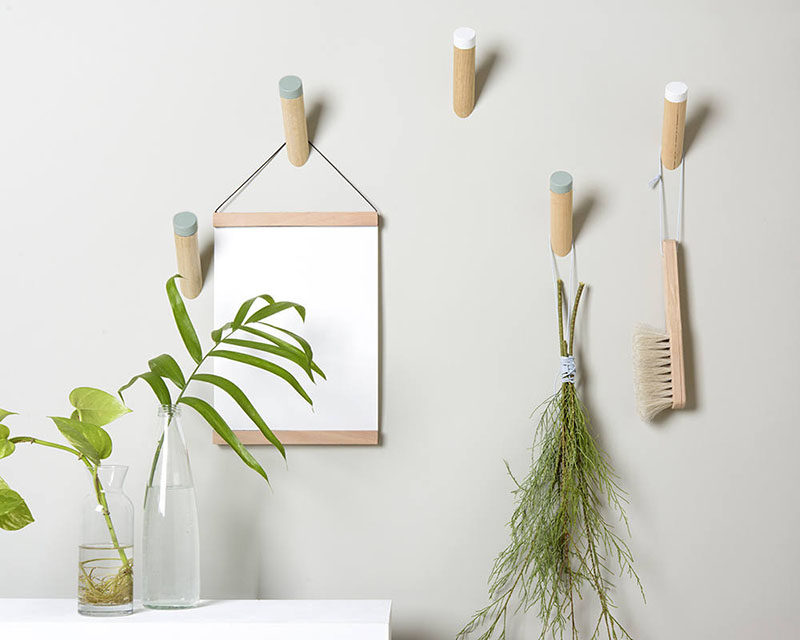 Simple dowel wall hooks with colored tips add a soft pop of color to otherwise plain walls.