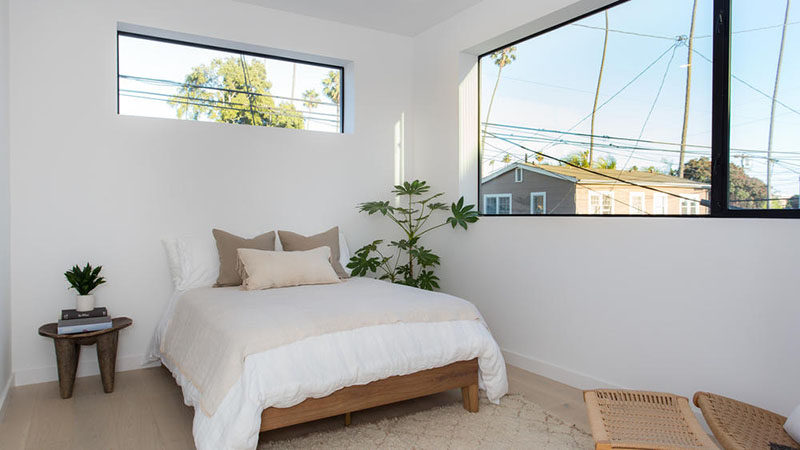 This modern bedroom is simple in its design, with white walls and wide oak flooring.