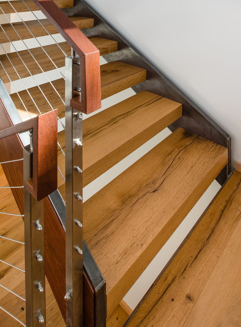 Steel and wood stairs lead to the upper floor of this modern house.