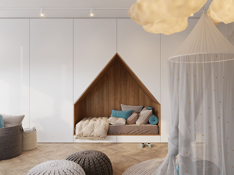 This modern bedroom design has a bed that's been built into a wall of floor-to-ceiling white cabinets, freeing up space to allow a large desk to sit under the window.