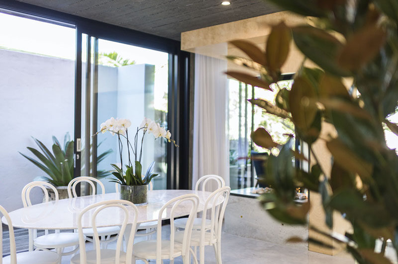 This contemporary dining room is furnished with a white oval dining table and complimentary chairs. #DiningRoom #InteriorDesign #WhiteDiningTable