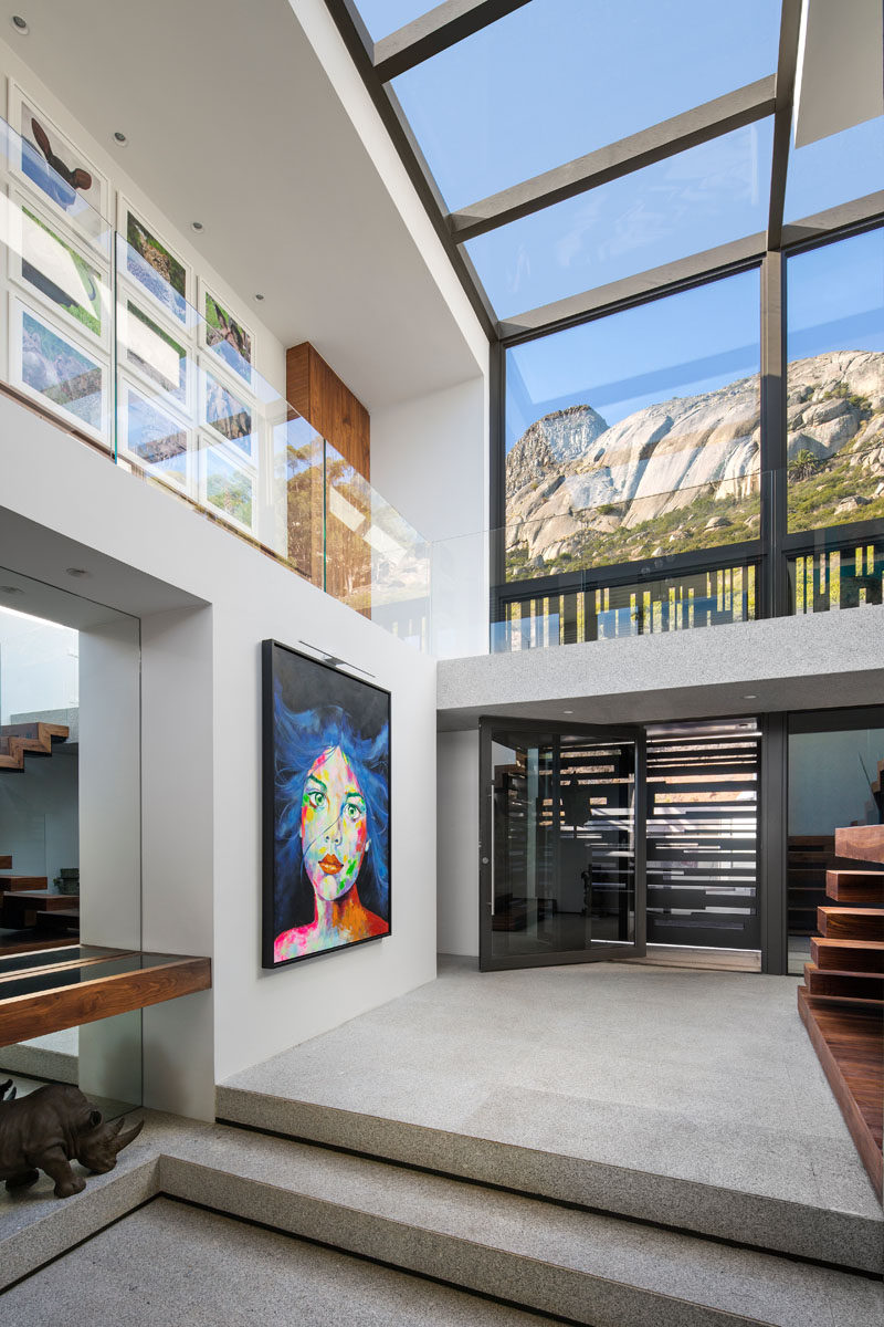 Stepping inside this modern house, double-height ceilings and windows that wrap around from the wall to the ceiling create a sense of openness and a dramatic entryway.