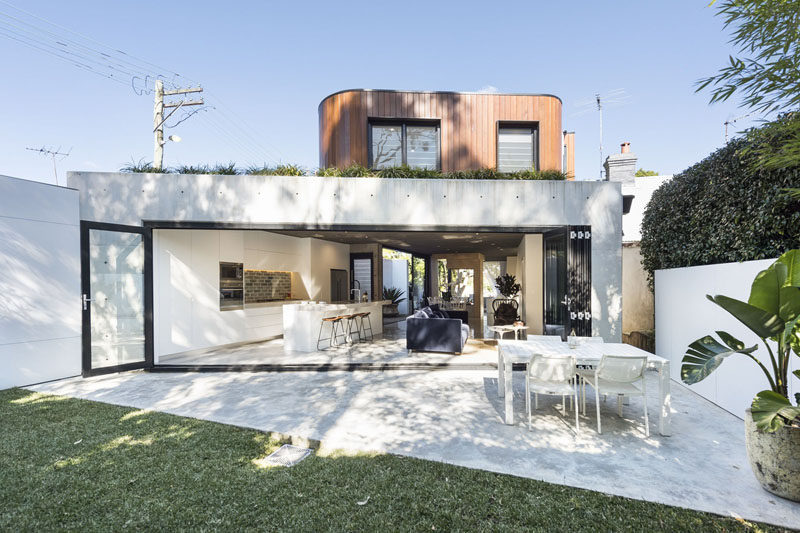 This modern house has a retractable glass wall that can be opened up to a private backyard that's ideal for indoor / outdoor living. #Architecture #RetractableGlassWall #Patio #Backyard