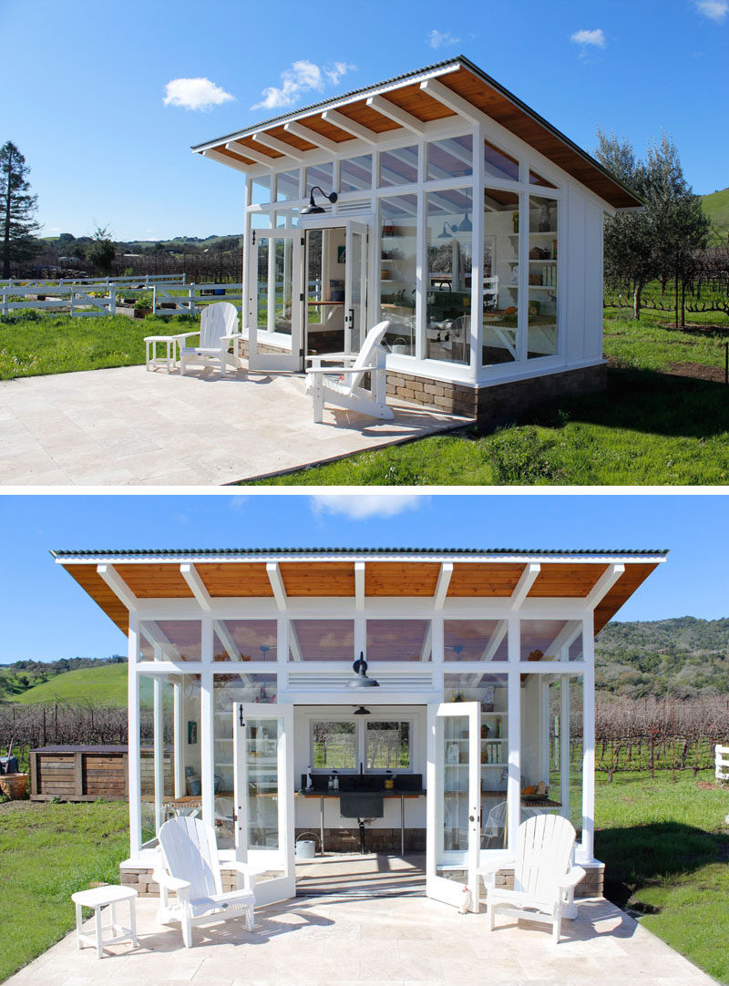 A modern potting shed with a patio, walls of windows, and a sloped roof.