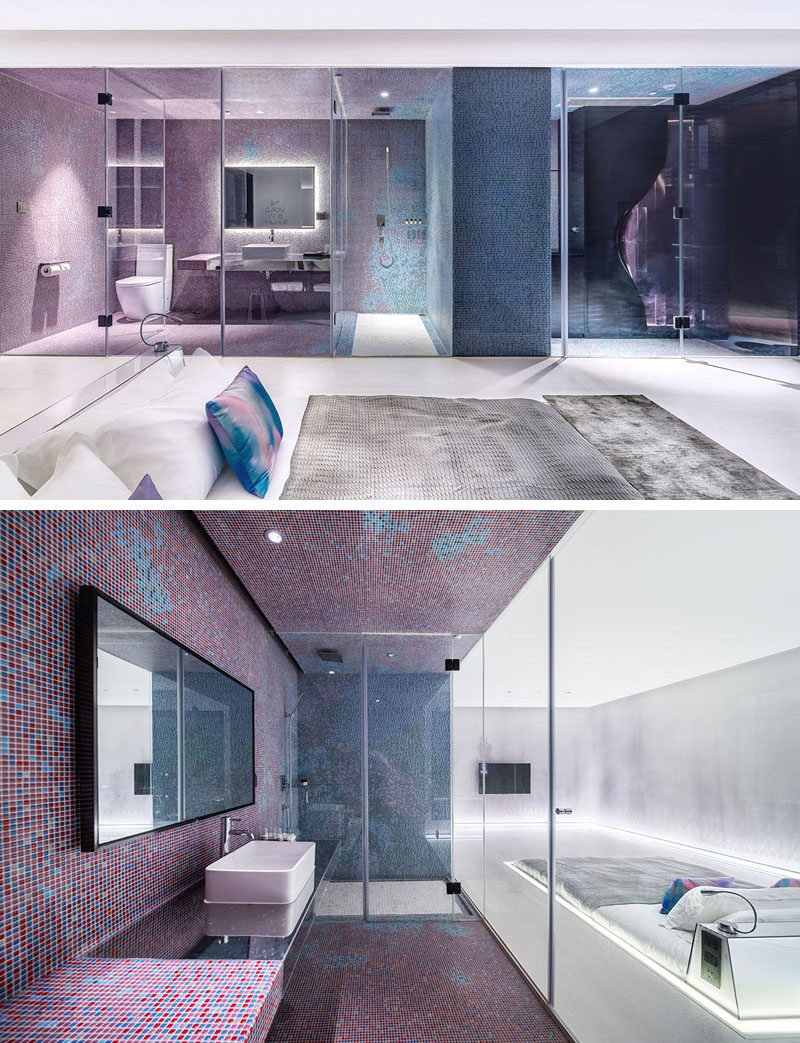 This futuristic modern hotel room features a sunken bed in the middle of the room. The bed sits flush with the floor, with only the headboard rising up from the floor.