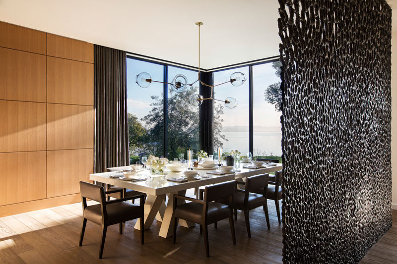 Large floor-to-ceiling windows allow plenty of natural light to fill this modern dining room. #Windows #BronzeScreen #DiningRoom