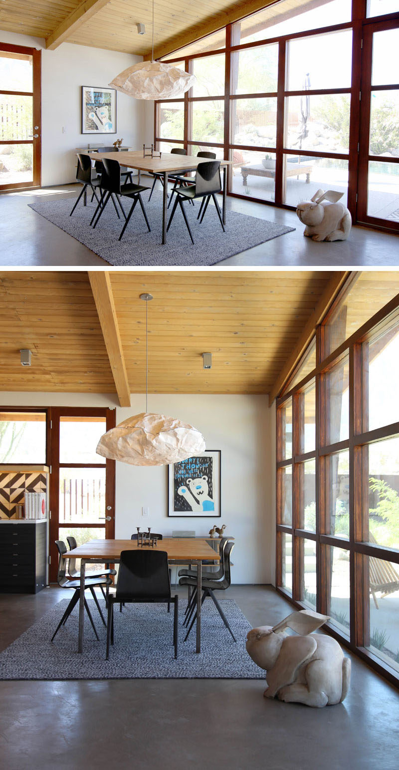 This dining room has a large cloud-like pendant light hanging above it, while a rug helps anchor the dining table and chairs in the open plan room. #DiningRoom #InteriorDesign #windows #modern