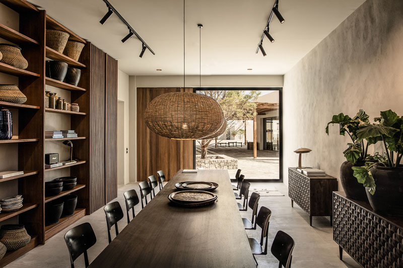 This contemporary hotel in Greece has a library with a large table, floor-to-ceiling shelving and access to a courtyard. #Library #Shelving #Hotel #Greece #InteriorDesign