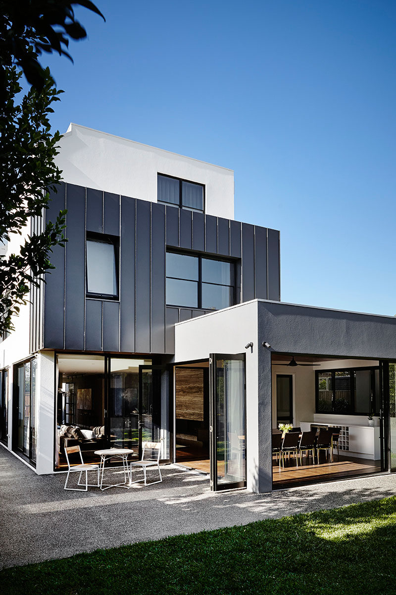 The back of this modern house has a casual dining room with folding doors that can be opened to the backyard, creating indoor/outdoor living.