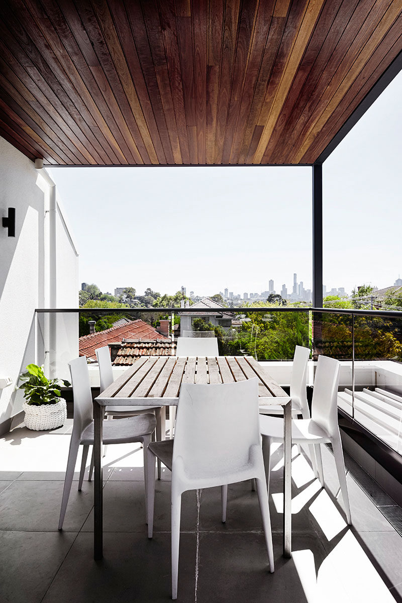 This wood covered rooftop deck has views of the neighborhood and city in the distance.