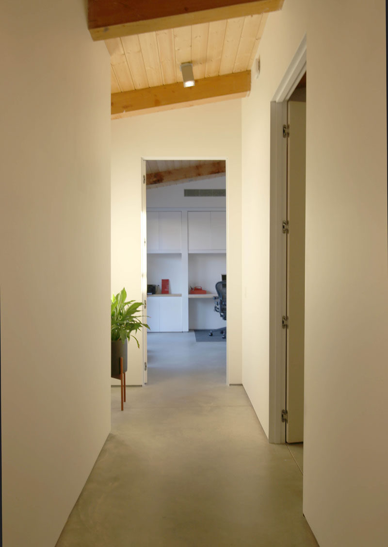 A simple hallway with concrete floors leads to the bedrooms in this modern house. #ConcreteFloors #InteriorDesign #hallway