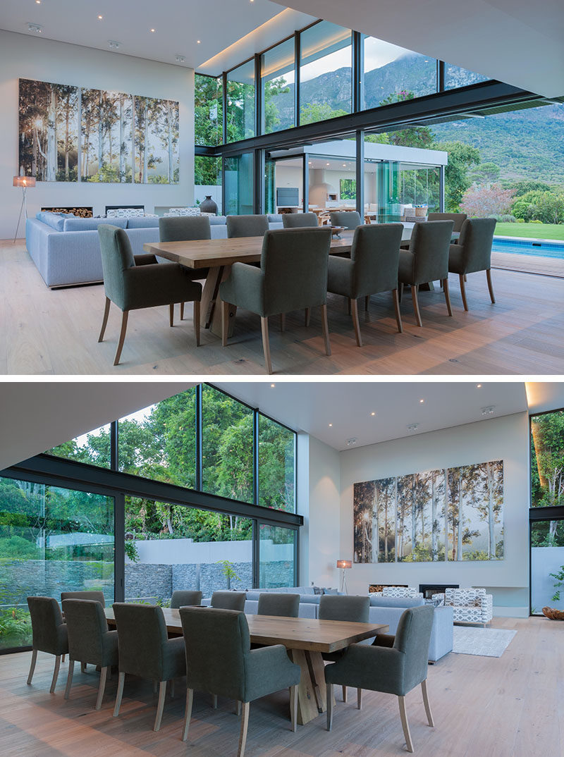 Large sliding glass doors can be opened on either side of this modern double height combined living and dining room. On one side is the swimming pool and on the other is a courtyard surrounded by a stone wall.