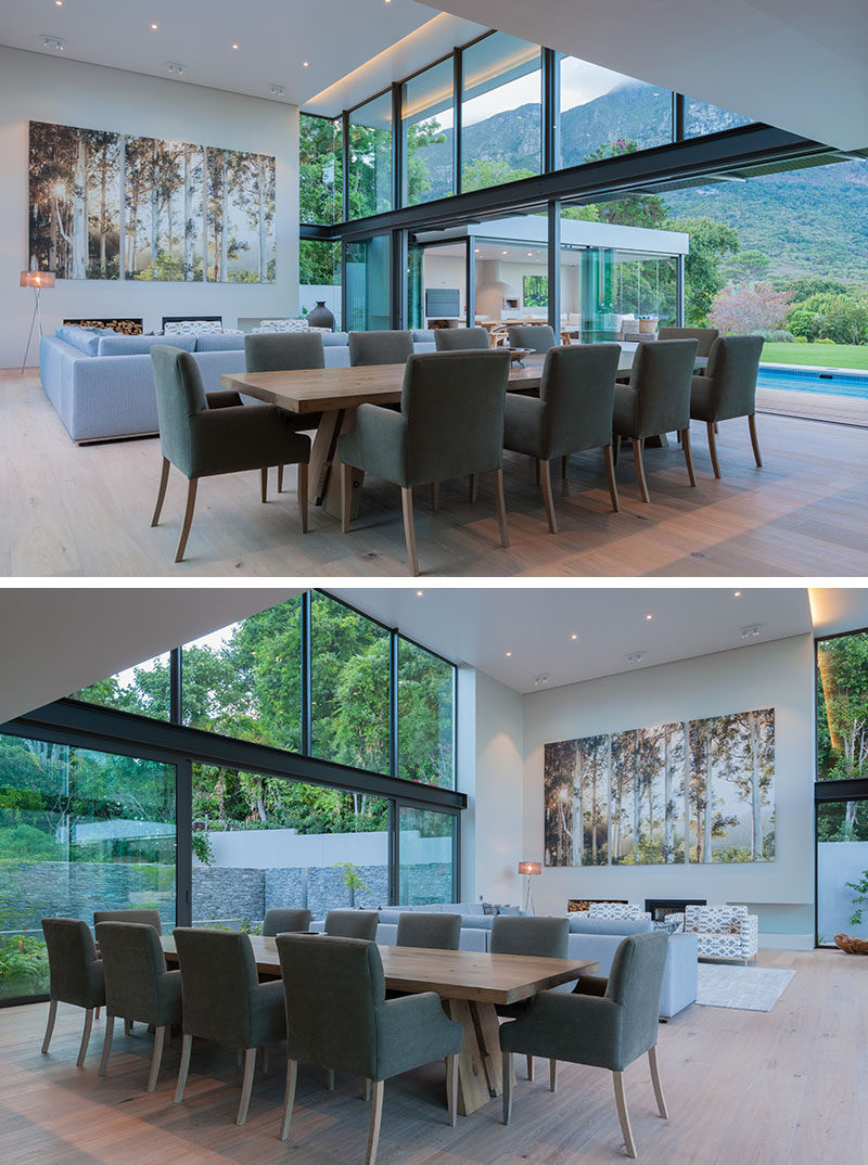 Large sliding glass doors can be opened on either side of this modern double height combined living and dining room. On one side is the swimming pool and on the other is a courtyard surrounded by a stone wall.